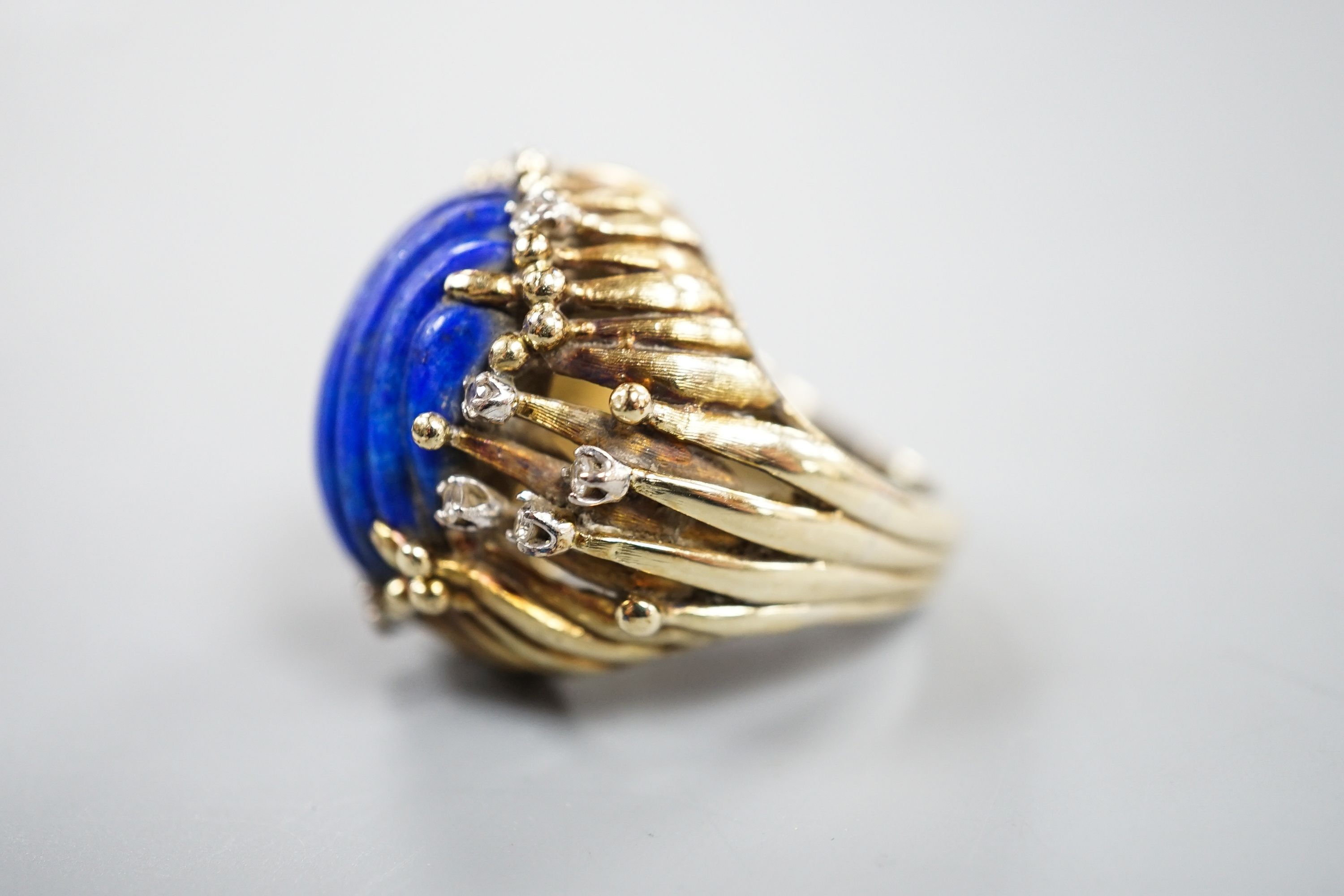 A pierced fluted 14k yellow metal, lapis lazuli and diamond set modernist dress ring, size K/L, gross weight 15.3 grams.